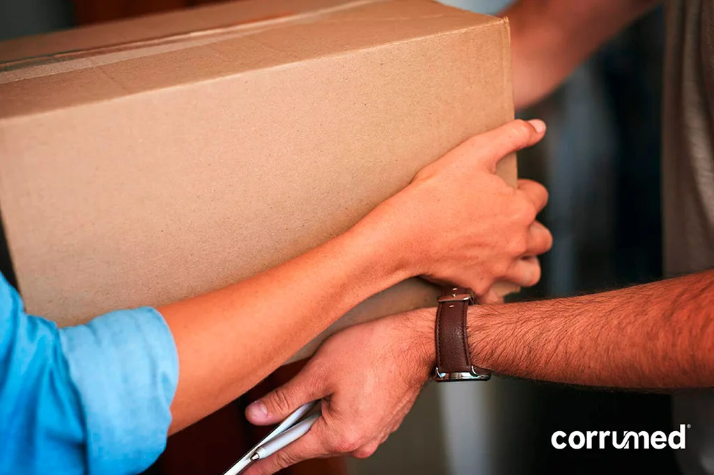 Persona transportando una caja de cartón corrugado diseñada para proteger productos frágiles durante la manipulación