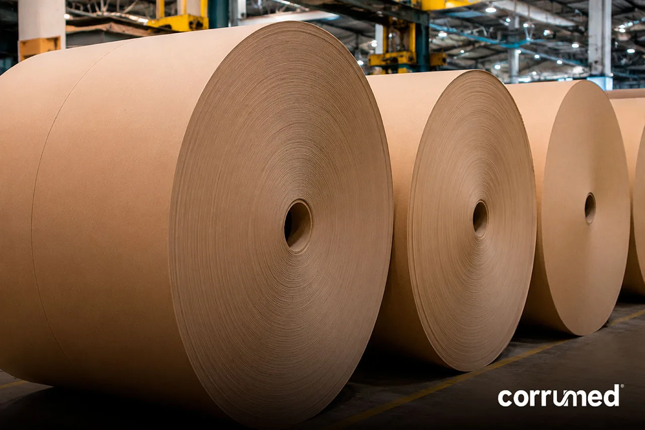 Bobinas jumbo de liner y fluting enrolladas para alimentar la corrugadora en la fabricación de cartón corrugado.