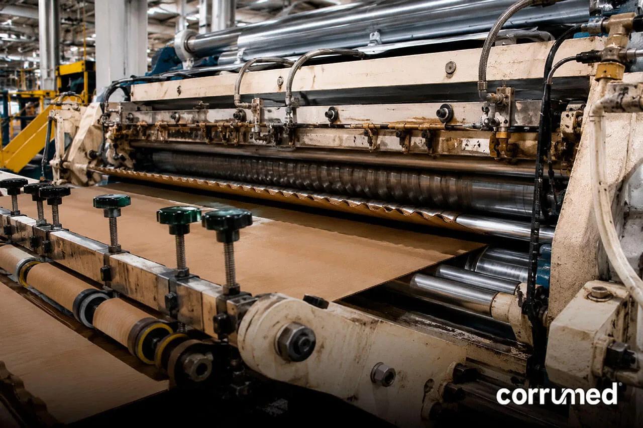 Corrugadora industrial formando cartón corrugado: proceso de ondulado y encolado de liner y fluting.